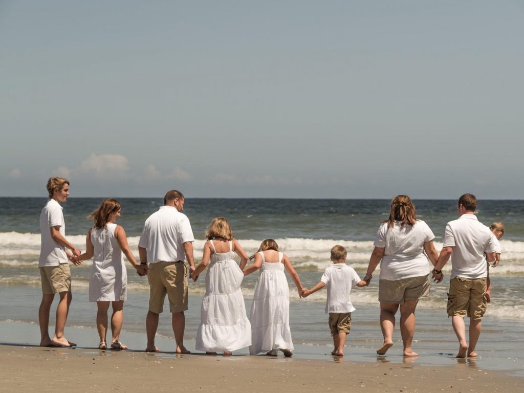 Family in all white standing on the beach